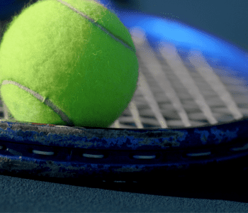 tennis ball resting on a tennis racquets