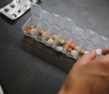 person sorting pills in a pil organizer