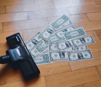 dollar bills being sucked into a vacuum